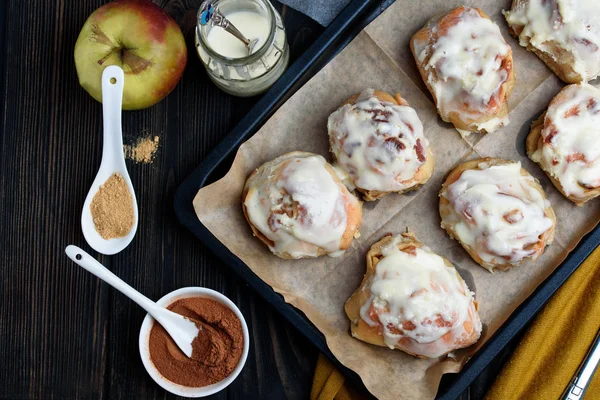 Sweet buns with a block and cinnamon on a dark background — Stock Photo, Image