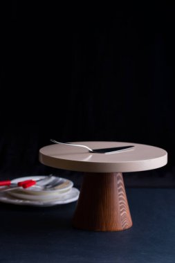 Kek standı ve siyah arka planda pasta spatulası.