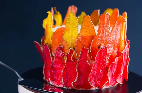 Beautiful and delicious dessert. The cake on the stand is decorated with red and yellow pears.