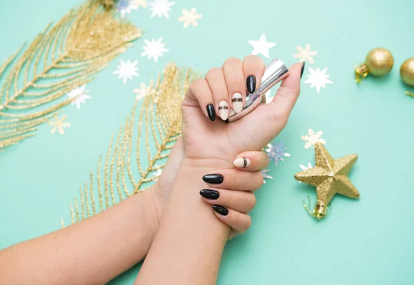 Mooie vrouwelijke manicure op een gekleurde achtergrond met een feestelijk element. Vakantie inhoud. — Stockfoto