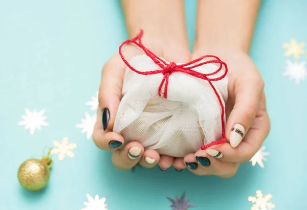 Mooie vrouwelijke manicure op een gekleurde achtergrond met een feestelijk element. Vakantie inhoud. — Stockfoto