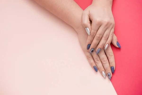 Mooie stijlvolle vrouwelijke manicure op een roze achtergrond. — Stockfoto