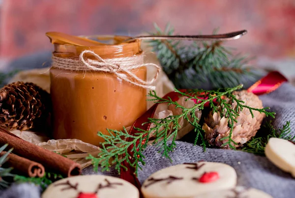 Christmas cookies with homemade salted caramel on a wooden background, neon lights, cinnamon sticks. — Stock Photo, Image