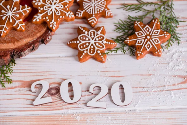Vánoční cukroví s domácím soleným karamelem na dřevěném pozadí, neonová světla, skořicové tyčinky. — Stock fotografie