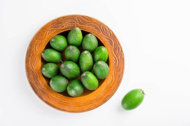 Beyaz bir arka planda izole edilmiş sulu ve olgun bir feijoa. Sağlıklı sonbahar meyvesi.