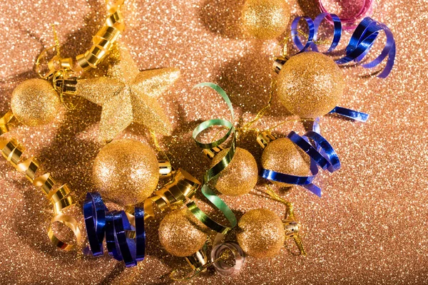 Festive content on a glittery background of gold color with serpentine, toys, sparkles.
