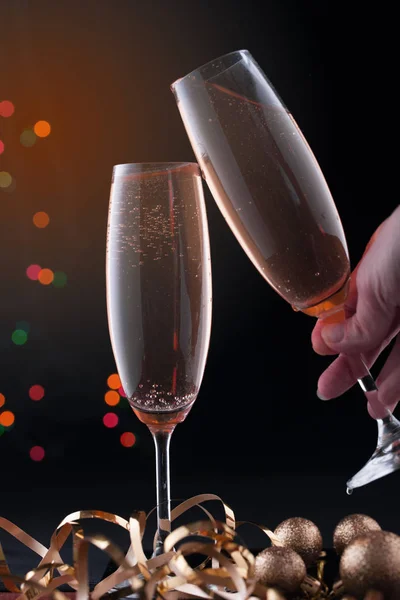Due bicchieri con champagne con luci festive su sfondo scuro . — Foto Stock