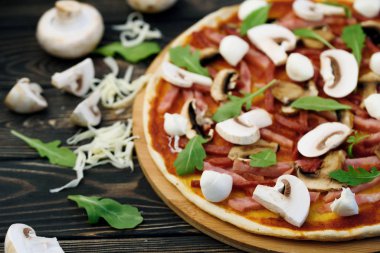 Lezzetli ve lezzetli pizza masanın üzerinde. İştah açıcı ev yapımı buzdolabının