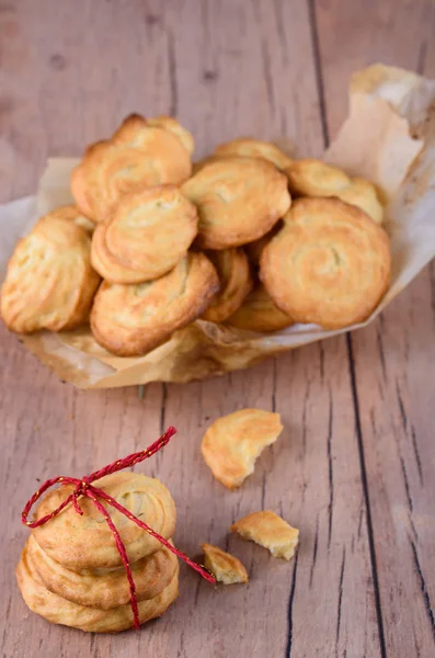 Galletas caseras sabrosas con papel pergamino sobre la mesa . — Foto de Stock