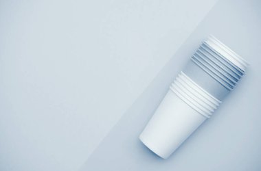 Mavi arka planda kağıt bardaklar. Kahve zamanı.