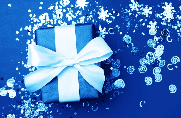 Kék ajándék doboz fehér íj rózsaszín háttér csillogás. Üdülési koncepció. — Stock Fotó