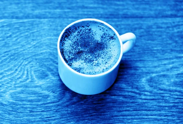 Coffee cup top view on old wooden with blue toned — Stock Photo, Image