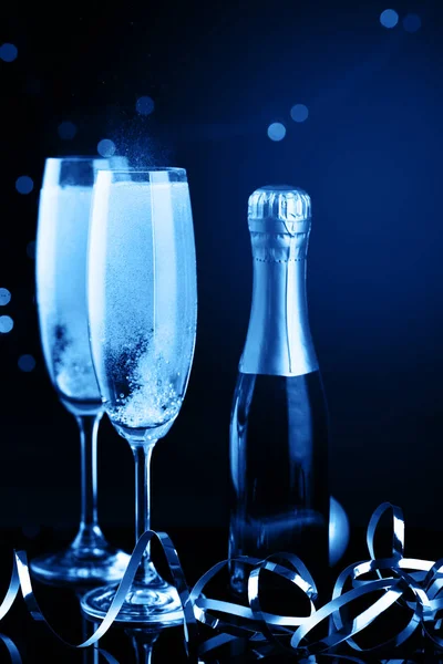 Två glas champagne mot suddiga julbelysning. kort skärpedjup. — Stockfoto