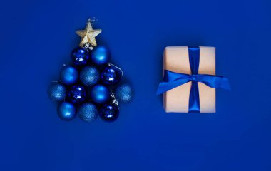 Mavi arka planda güzel bir saten kurdeleli yeni yıl hediyesi. Noel zamanı. Yeni Yıl İçeriği.