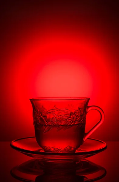 Один стакан с рисунком, с ароматным чаем на красном фоне — стоковое фото