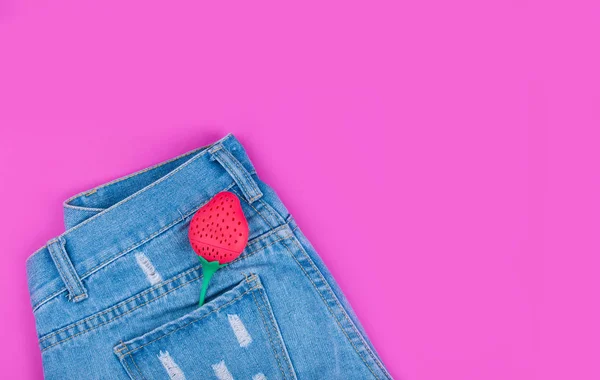 Short denim tendance avec fraises dans la poche arrière sur fond rose . — Photo