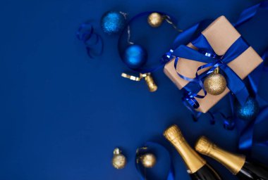 Mavi arka planda güzel bir saten kurdeleli yeni yıl hediyesi. Noel zamanı. Yeni Yıl İçeriği.