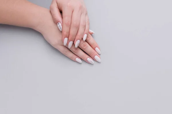 Hermosa manicura femenina con estilo sobre un fondo gris . —  Fotos de Stock