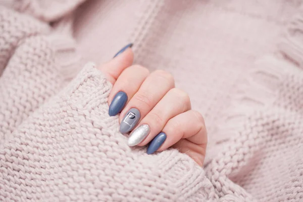 Mooie vrouwelijke manicure op een zachte trui trui. — Stockfoto