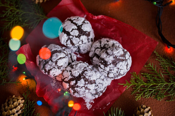 Вкусные и ароматные шоколадные печенья измельчаются с сахарной пудрой, с разноцветными огнями на столе. Счастливого Рождества!
