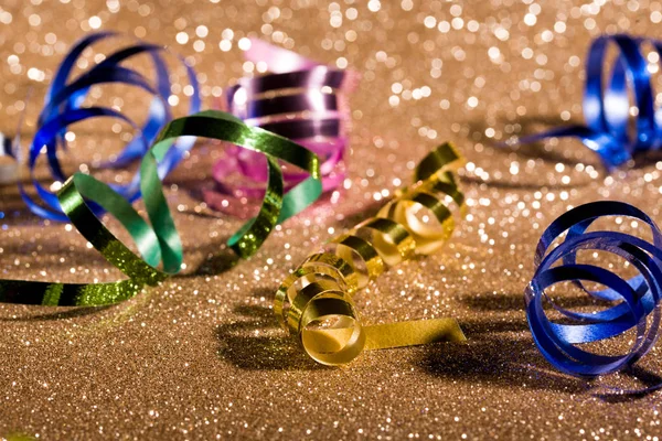 Festive content on a glittery background of gold color with serpentine, toys, sparkles.