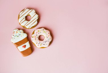 Pembe arka plan doğum günü dekorasyonunda büyük çörek ve zencefilli çörek.