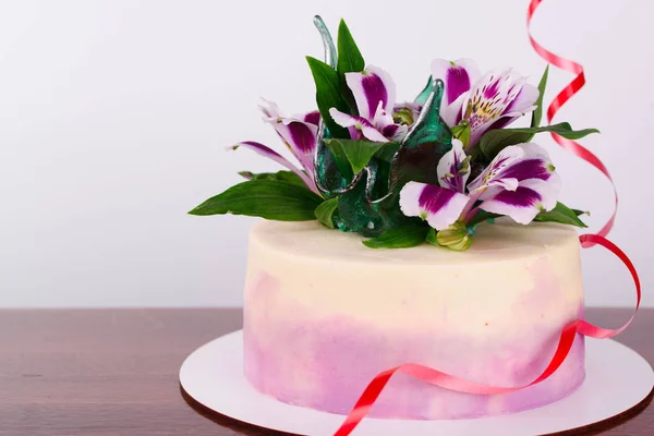 Delicious beautiful cake is impregnated with tender cream, decorated with flowers. — Stock Photo, Image