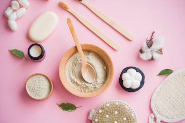 Kozmetik banyo tuzu, yüz için üzüm gomaj, pembe arka planda vücut için kahve fırçası..