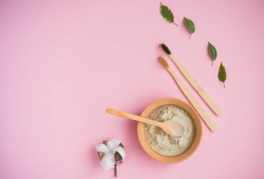 Kozmetik banyo tuzu, yüz için üzüm gomaj, pembe arka planda vücut için kahve fırçası..