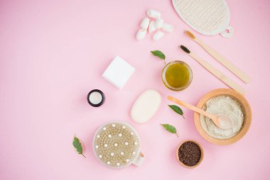 Kozmetik banyo tuzu, yüz için üzüm gomaj, pembe arka planda vücut için kahve fırçası..