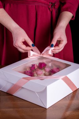 Zarif ve lezzetli bir mektup pastası olan şekerlemecinin elleri. Canlı çiçekli pasta, beyaz çikolata, beas. Bir pasta şefinin elleri, tatlı paketliyor..