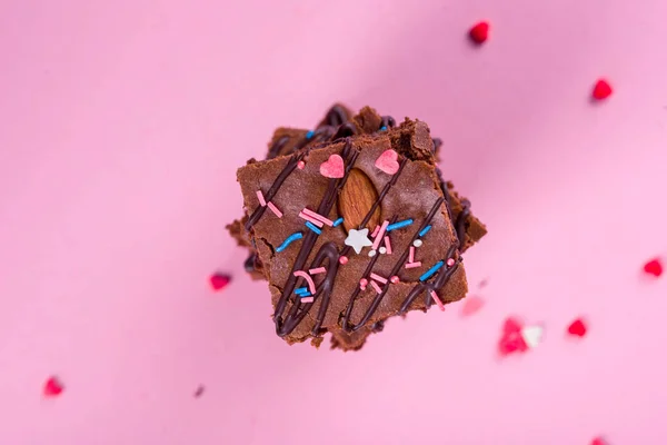 Десертный шоколадный брауни с миндалем грецкого ореха, на розовом фоне. Вкусные и сладкие десерты . — стоковое фото