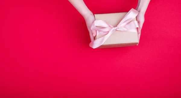 Eine schöne Geschenkbox mit Satinband in der Hand. — Stockfoto