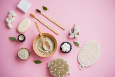 Kozmetik banyo tuzu, yüz için üzüm gomaj, pembe arka planda vücut için kahve fırçası..