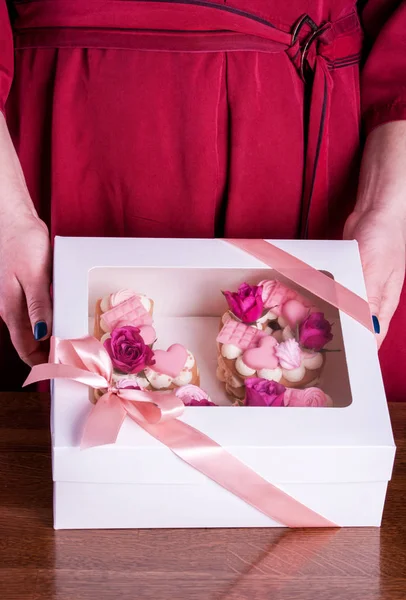 The hands of the confectioner with a delicate and delicious cake of letters.