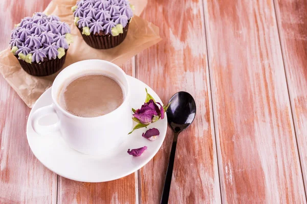 Choklad läcker cupcake med grädde och doftande kaffe med mjölk på ett vitt träbord. — Stockfoto