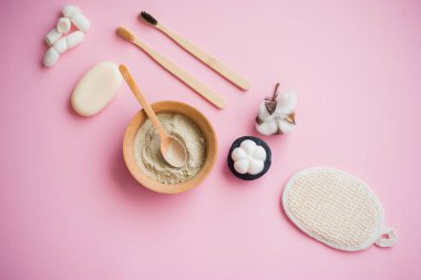 Kozmetik banyo tuzu, yüz için üzüm gomaj, pembe arka planda vücut için kahve fırçası..