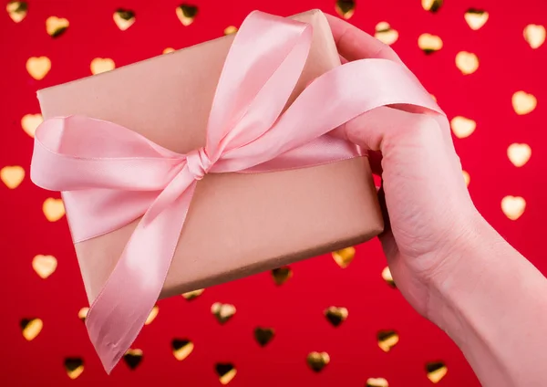 Uma bela caixa de presente com fita de cetim na mão . — Fotografia de Stock