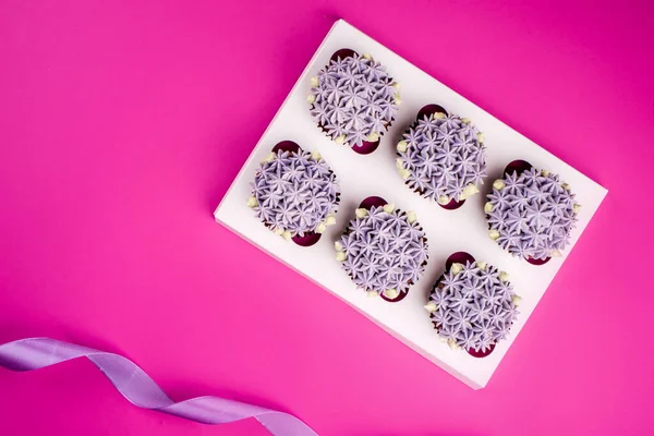 Вкусные Шон кексы с творожным кремом в виде цветов на розовом фоне . — стоковое фото