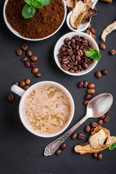 Mushroom Chaga Coffee Superfood Trend-dry and fresh mushrooms and coffee beans on dark background with mint.