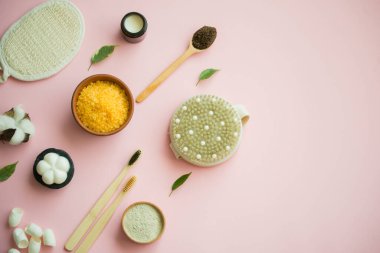 Kozmetik banyo tuzu, yüz için üzüm gomaj 'ı pembe arka planda vücut için kahve fırçası. Sıfır kablo, eko, organik kozmetik.