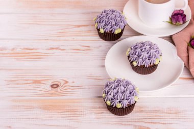 Kremalı çikolatalı kek ve beyaz ahşap bir masada sütlü kokulu kahve. Tatlı olarak beyaz yemekler.