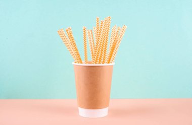 İçme tüplü kağıt bardak. Hafif arka planda eko aletler. Sıfır israf. Sürdürülebilir yaşam tarzı kavramı