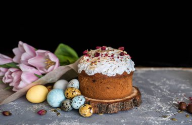 Paskalya kompozisyonu tatlı ekmek, kulich ve hafif arka planda yumurtalar. Paskalya tatili kahvaltı konsepti.