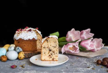 Paskalya kompozisyonu tatlı ekmek, kulich ve hafif arka planda yumurtalar. Paskalya tatili kahvaltı konsepti.
