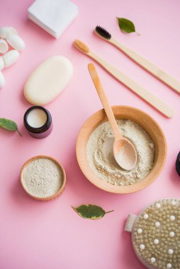 Kozmetik banyo tuzu, yüz için üzüm gomaj 'ı pembe arka planda vücut için kahve fırçası. Sıfır kablo, eko, organik kozmetik.