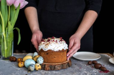 Paskalya kompozisyonu tatlı ekmek, kulich ve hafif arka planda yumurtalar. Paskalya tatili kahvaltı konsepti.
