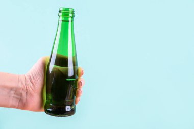 Cam bir su şişesi açık arkaplanda parlak yeşildir.