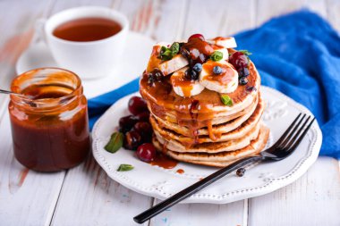 Işık masasında nefis bir kahvaltı. Muzlu ve tuzlu karamelli mavi bir tabakta krep.