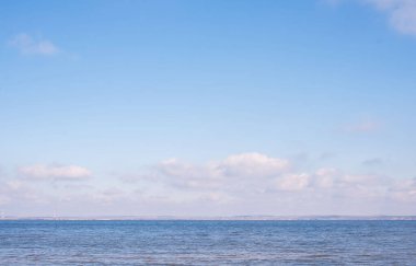 Mavi gökyüzünde yüzen bulutlarla güzel deniz manzarası. Yaz güneşli bir gün